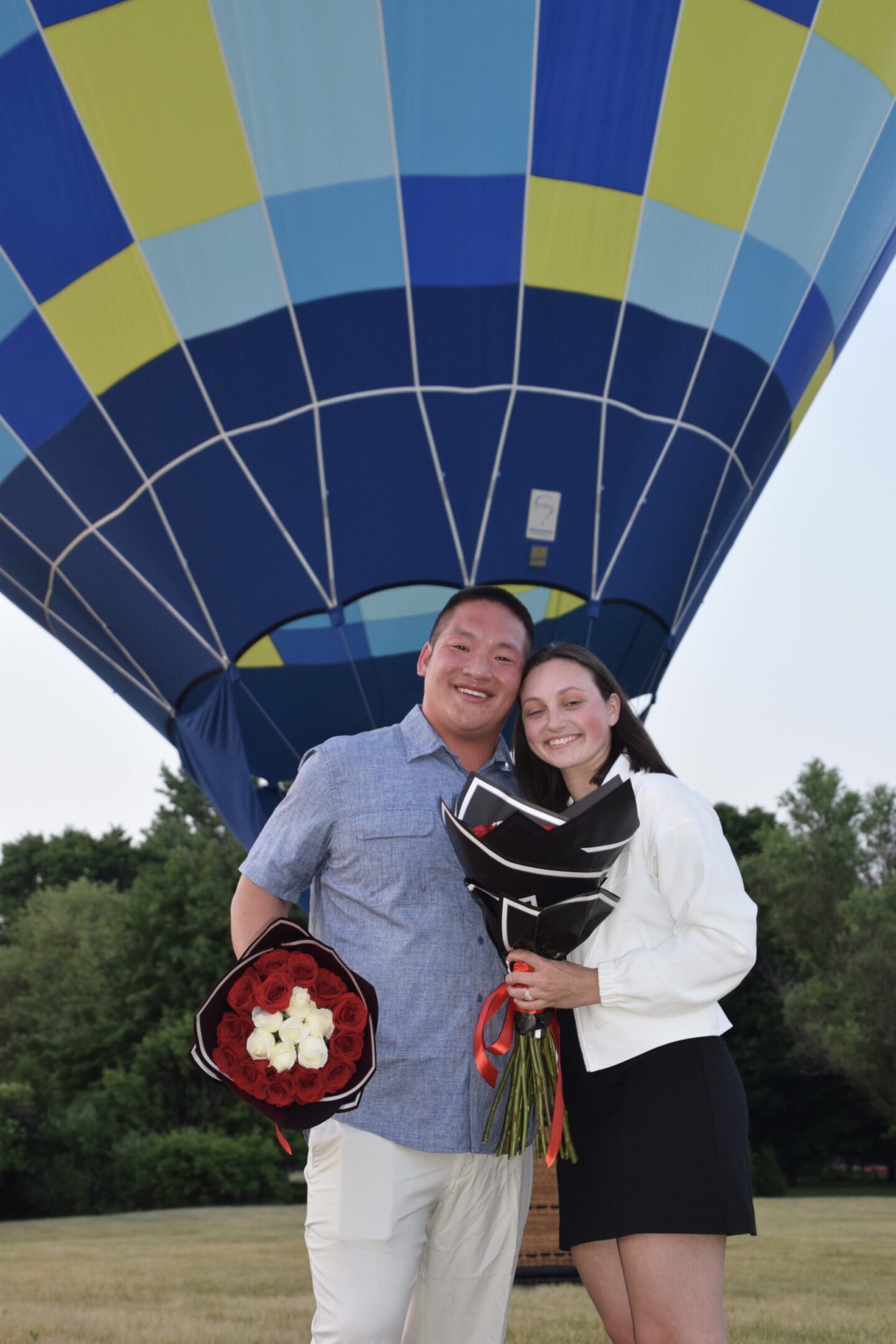 Couple holding flowers by hot air balloon
