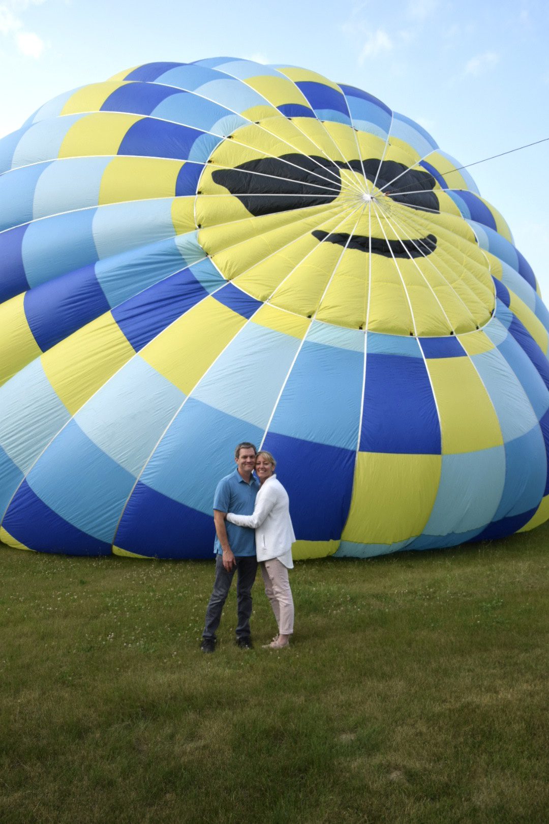 Couple standing by smiling hot air balloon