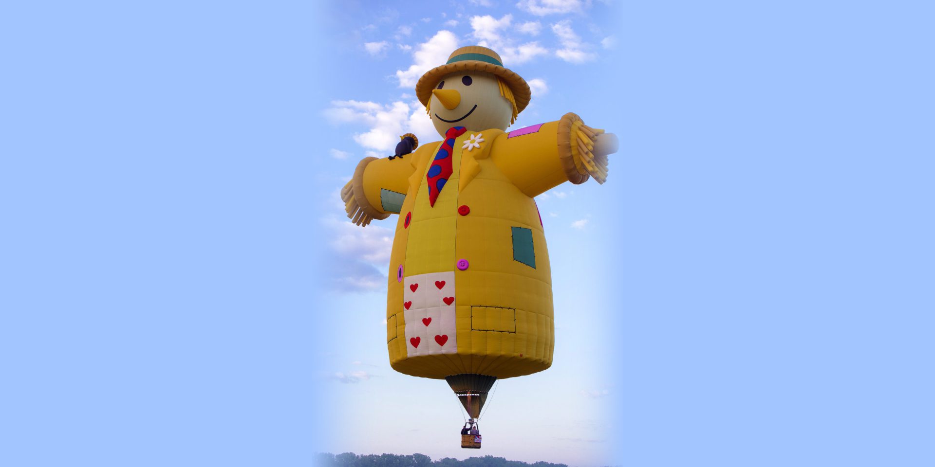 Scarecrow-shaped hot air balloon against sky
