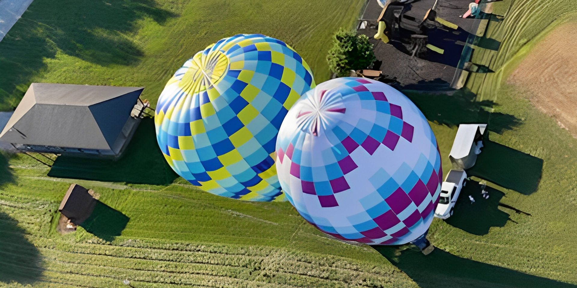 Two colorful hot air balloons on grass
